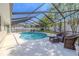 Sparkling screened-in pool surrounded by comfortable seating and lush landscaping, perfect for outdoor entertainment at 465 Holly Hill Rd, Oldsmar, FL 34677