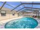 Sparkling screened in pool with blue tiling, surrounded by a white concrete patio at 465 Holly Hill Rd, Oldsmar, FL 34677