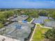 Aerial view of multiple tennis courts at Ardea Country Club, surrounded by landscaping and lush green trees at 465 Holly Hill Rd, Oldsmar, FL 34677
