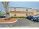 View of the exterior of a two-story tan condominium building, showcasing parking spaces at 4708 Michael Ct # 103, Tampa, FL 33614