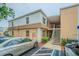Two-story condo building with tan stucco and white siding, featuring stairs to upper-level units and designated parking at 4708 Michael Ct # 103, Tampa, FL 33614
