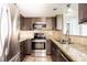 Modern kitchen featuring stainless steel appliances, granite countertops, and dark wood cabinets at 4708 Michael Ct # 103, Tampa, FL 33614