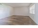 Bright living room with light-colored walls, wood-look floors, and a window with blinds at 4708 Michael Ct # 103, Tampa, FL 33614