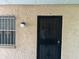 Tan stucco building featuring a black security door, barred windows, unit 104 at 4708 Michael Ct # 104, Tampa, FL 33614
