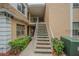 Exterior view of a condo complex with well-maintained stairs, landscaping, and building facade at 4708 Michael Ct # 104, Tampa, FL 33614