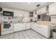 Bright kitchen featuring white cabinets, granite counters, and an open layout to the living area at 4735 W Leila Ave, Tampa, FL 33616