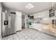 Functional kitchen with white cabinets, granite countertops, and stainless steel refrigerator at 4735 W Leila Ave, Tampa, FL 33616