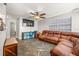 Comfortable living room featuring a plush leather sofa, ceiling fan, and modern flooring at 4735 W Leila Ave, Tampa, FL 33616