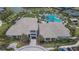 An aerial view of the community's clubhouse and luxurious pool with ample seating and palm trees at 4795 Freccia Loop, Wesley Chapel, FL 33543