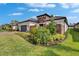 Charming single-Gathering home boasting stone accents, tile roof, landscaped yard, and brick driveway at 4795 Freccia Loop, Wesley Chapel, FL 33543