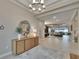 Elegant foyer with large round mirror, console table, and access to open-concept living areas at 4795 Freccia Loop, Wesley Chapel, FL 33543