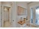 Inviting foyer with view of half-bath, decorative painting, glass console table, and front door at 4795 Freccia Loop, Wesley Chapel, FL 33543