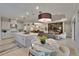 Bright, open kitchen flows into the living and dining areas with a large island and modern lighting fixtures at 4795 Freccia Loop, Wesley Chapel, FL 33543