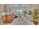 Comfortable living room with ceiling fan, leather sofa, and ample natural light from the window at 4795 Freccia Loop, Wesley Chapel, FL 33543