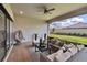 Relaxing covered patio featuring comfortable seating, ceiling fan, and serene backyard views at 4795 Freccia Loop, Wesley Chapel, FL 33543