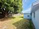 Backyard featuring a grassy area with mature tree and a wooden fence at 4836 Daphne St, New Port Richey, FL 34652