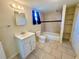 Well-lit bathroom featuring a shower-tub combo, vanity, and closet with built-in shelving at 4836 Daphne St, New Port Richey, FL 34652