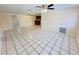Spacious living area showcasing tile floors and ceiling fans, with a view into the kitchen at 4836 Daphne St, New Port Richey, FL 34652