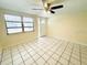 Bright living room featuring tile floors, ceiling fan, and large windows for ample natural light at 4836 Daphne St, New Port Richey, FL 34652