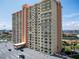 Low angle showcases the building's facade, featuring multiple balconies and a covered entrance, surrounded by lush greenery at 4900 Brittany S Dr # 613, St Petersburg, FL 33715