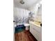 Compact bathroom features wood-look flooring, shower and tub combo, and ample lighting at 4902 Panorama Ave, Holiday, FL 34690