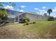 View of backyard with screened enclosure, landscaping and well-maintained lawn at 5102 Coastal Scene Dr, Apollo Beach, FL 33572