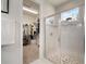 Bright bathroom features a glass shower with tile surround and a view into the walk-in closet with ample shelving at 5102 Coastal Scene Dr, Apollo Beach, FL 33572