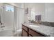 Bright bathroom features a granite-topped vanity, tub-shower combo, and natural light at 5102 Coastal Scene Dr, Apollo Beach, FL 33572