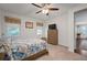 Neutral bedroom featuring a ceiling fan, two windows and view to living area at 5102 Coastal Scene Dr, Apollo Beach, FL 33572