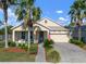 Inviting one-story home with an attached garage, landscaped garden, and charming front porch area at 5102 Coastal Scene Dr, Apollo Beach, FL 33572