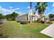 Side view of a single-Gathering home featuring a spacious green lawn, manicured landscaping, and a charming front porch at 5102 Coastal Scene Dr, Apollo Beach, FL 33572