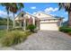 Beautifully landscaped home with a well-maintained lawn, inviting front porch, and an attached two-car garage at 5102 Coastal Scene Dr, Apollo Beach, FL 33572