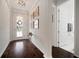 Inviting foyer with gleaming hardwood floors, elegant lighting, and convenient access to a nearby bathroom at 5102 Coastal Scene Dr, Apollo Beach, FL 33572