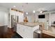 Open concept kitchen with stainless steel appliances and center island overlooks the adjacent living area at 5102 Coastal Scene Dr, Apollo Beach, FL 33572
