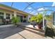 Backyard patio with a screen enclosure, wooden deck, outdoor seating, and landscaped areas with tropical plants at 5102 Coastal Scene Dr, Apollo Beach, FL 33572