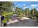Inviting screened lanai features comfortable seating on wood deck overlooking the lush backyard at 5102 Coastal Scene Dr, Apollo Beach, FL 33572