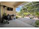 Beautiful screened patio with wood deck, grill, and seating area with a television, perfect for outdoor entertaining at 5102 Coastal Scene Dr, Apollo Beach, FL 33572