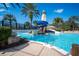 Gathering friendly pool area with a lighthouse, water slide, bridge, and lush tropical landscaping at 5102 Coastal Scene Dr, Apollo Beach, FL 33572