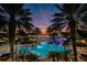 Resort-style pool area with lush landscaping, palm trees, slide, and relaxing waterfront sunset views at 5102 Coastal Scene Dr, Apollo Beach, FL 33572