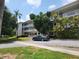 Exterior view of a multi-story condo with balconies, lush greenery and a parked car at 5155 9Th N Ave # 206 B, St Petersburg, FL 33710