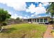 Large backyard with a wood fence, green grass, and a sunroom on the home at 5675 Lown N St, St Petersburg, FL 33714