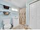 Bright bathroom featuring a toilet, vanity, shelving and shower with a themed curtain at 5675 Lown N St, St Petersburg, FL 33714