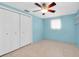 Bedroom showcasing spacious closet, blue walls, tiled floor, ceiling fan and floating shelves at 5675 Lown N St, St Petersburg, FL 33714
