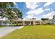 Charming single-story home with a lush green lawn, covered front porch, and carport with solar panels at 5675 Lown N St, St Petersburg, FL 33714