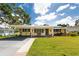 Charming single-story home with a lush green lawn, covered front porch, and carport at 5675 Lown N St, St Petersburg, FL 33714