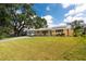 Charming single-story home with a lush green lawn, covered front porch, and carport with solar panels at 5675 Lown N St, St Petersburg, FL 33714