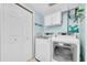 Updated laundry room with front loading washer and dryer, storage cabinet, and closet at 5675 Lown N St, St Petersburg, FL 33714