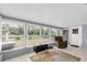 Bright sunroom features many windows, neutral tile flooring, and a comfortable chair at 5675 Lown N St, St Petersburg, FL 33714