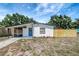 View of a single-story home with a screened porch, updated paint, and newer landscaping and a recently installed fence at 6014 S 82Nd St, Tampa, FL 33619