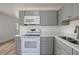 Bright kitchen features modern white appliances and grey shaker style cabinets at 6014 S 82Nd St, Tampa, FL 33619